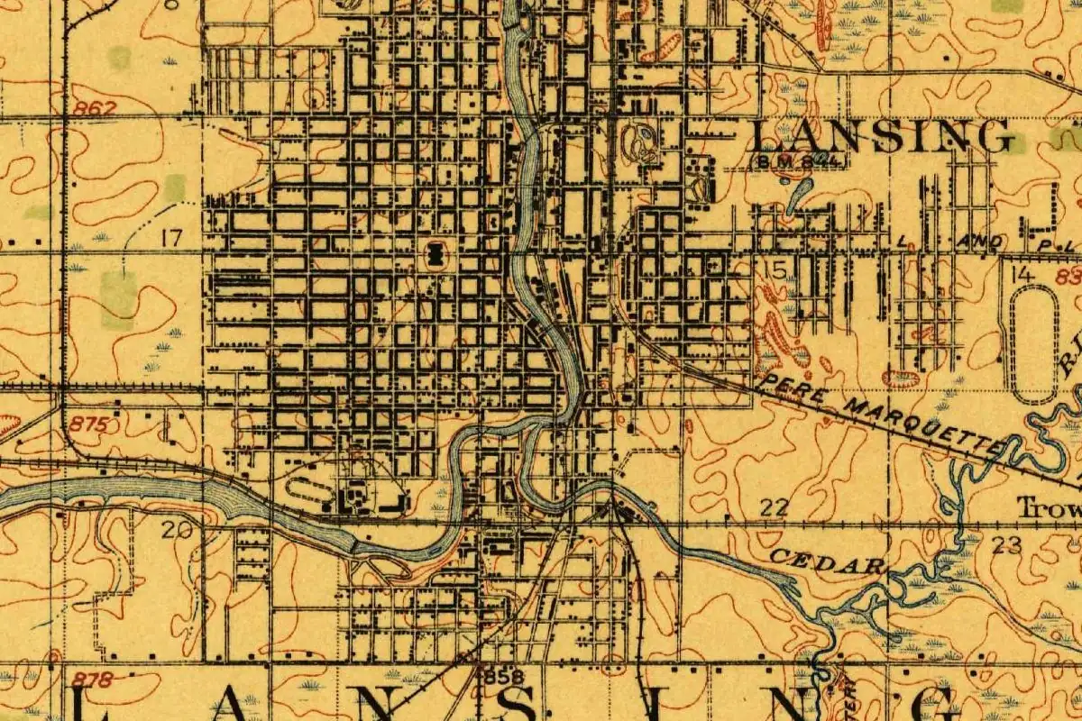 Detail of a 1912 U.S. Geological Survey map showing the street grid of Lansing on both sides of a winding river, with the Cedar River coming in from the lower right and the township name Lansing printed in large letters along the bottom
